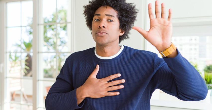 Man with hand on heart and one hand in the air, promising