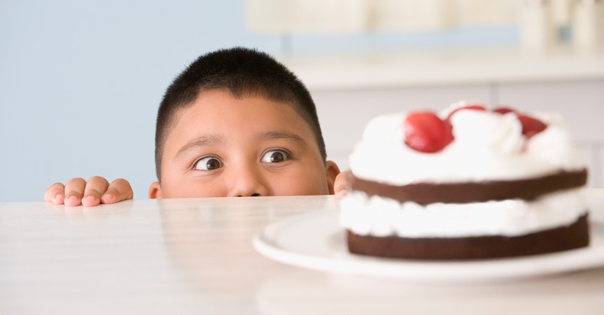 Boy being tempted by a cake on the counter