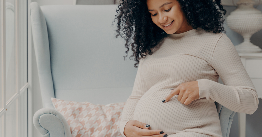 Pregnant woman sitting down by a window, prayers for pregnancy