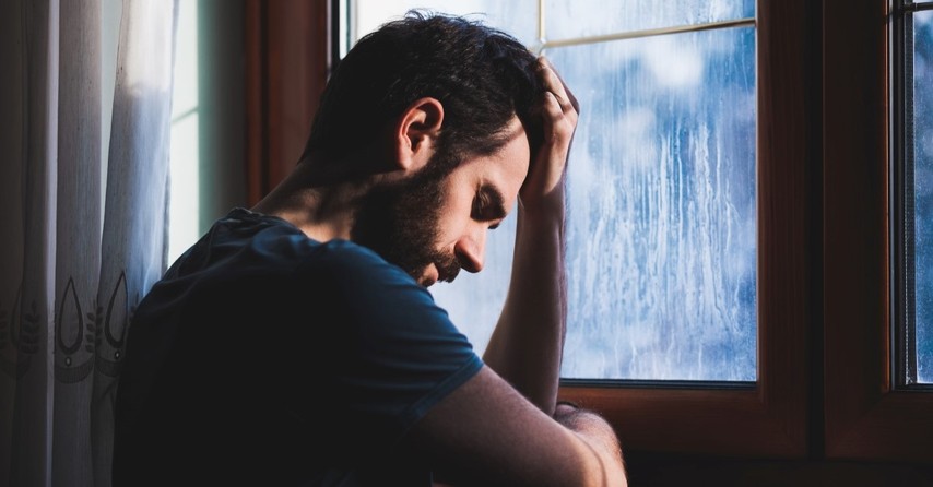 suffering man leaning on windowsill looking at rain, though he slay me