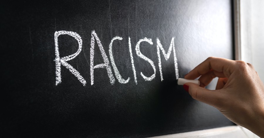 The word racism written on a blackboard, Praying for an end to racism for Pentecost