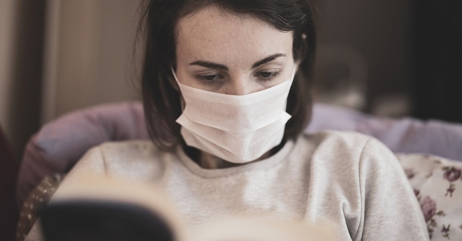 A woman reading and wearing a medical mask, Evangelical churches in the south and midwest are starting to meet