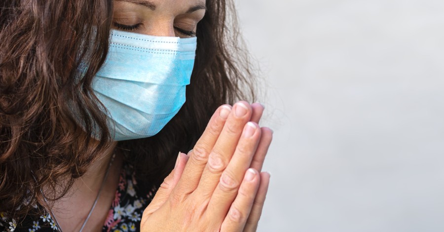 woman with coronavirus face mask praying for school year