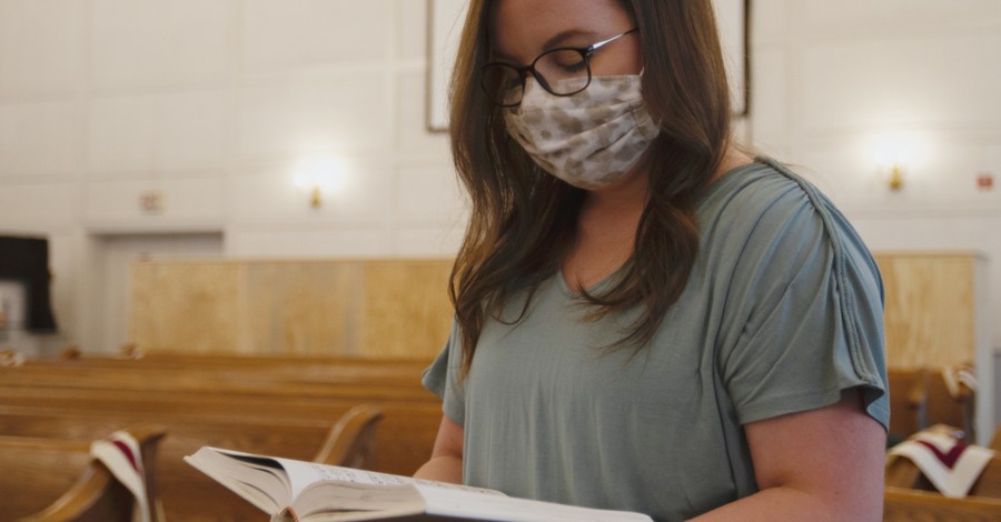 A woman in church wearing a mask, California changes their indoor worship services rules