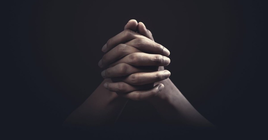praying hands confession dark room