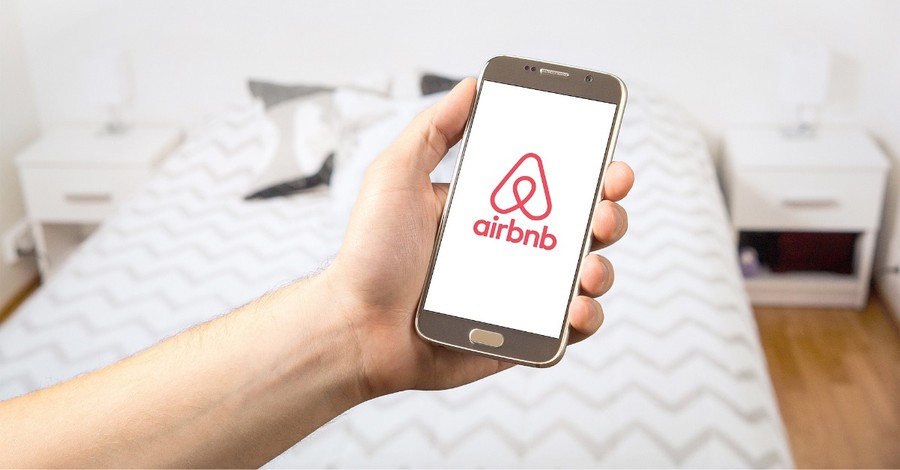 airbnb app on a phone, Airbnb offers homes to 20,000 afghan refugees