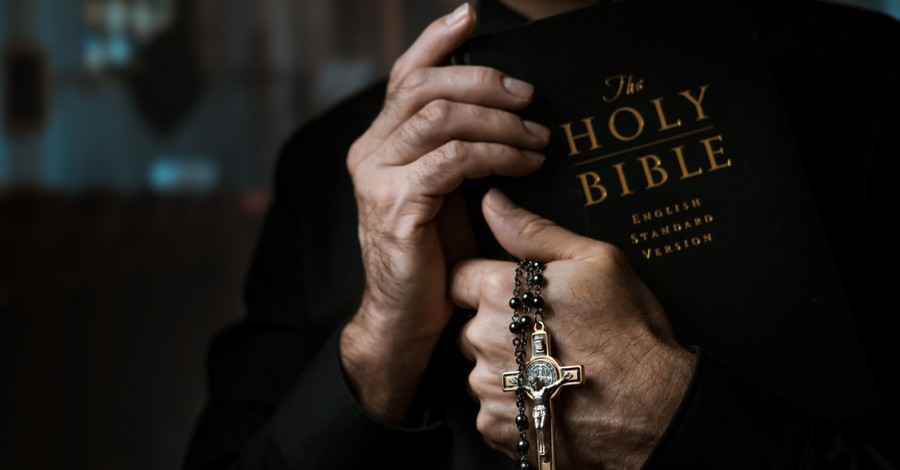 A Priest holding a Bible and cross, Catholic priest says requests for exorcisms are on the rise
