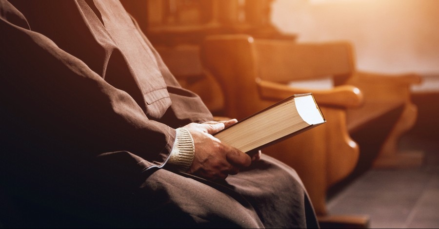 Pastor holding a Bible in a pew