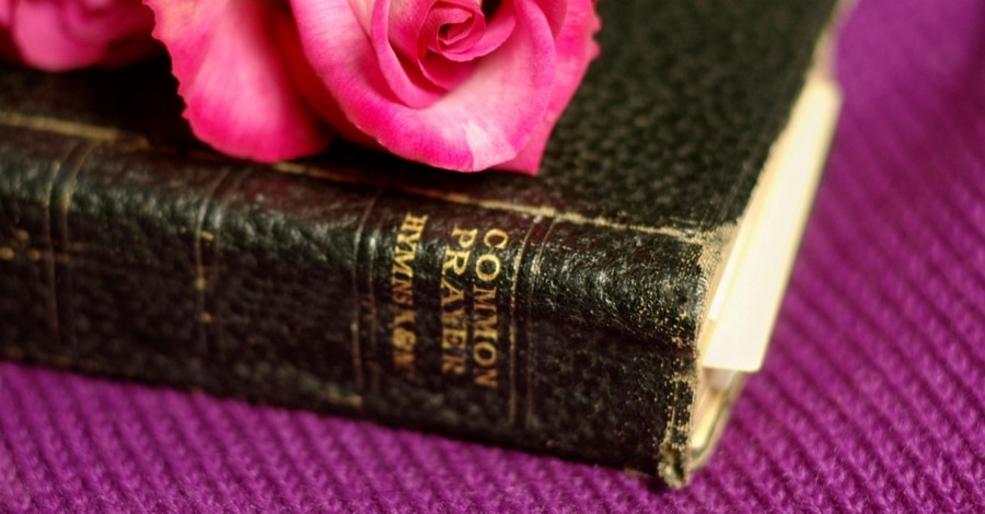 Book of Common Prayer with a pink rose on top of it, the prayers of the saints