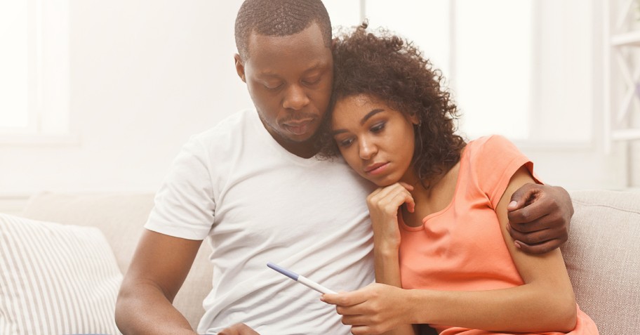 Worried couple looking at a pregnancy test