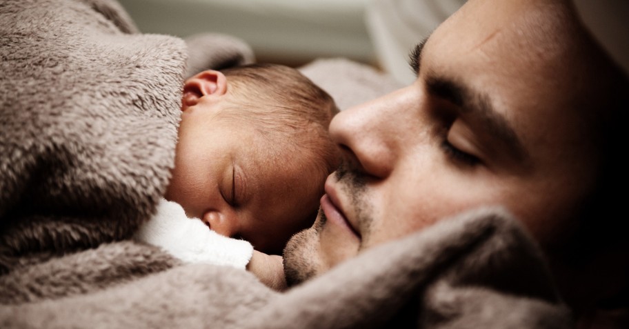 closeup of dad sleeping with newborn