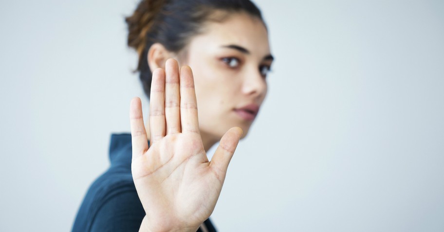 woman with hand up to camera rejecting