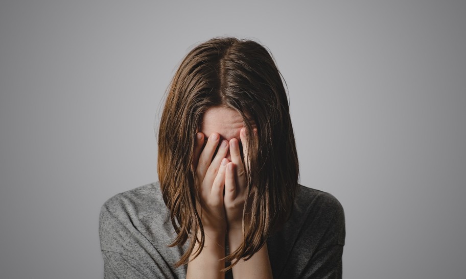 close up of woman holding face in hands, why we need to talk about shame