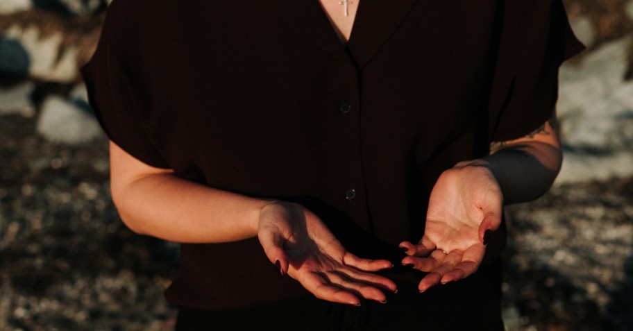 woman holding hands out on beach