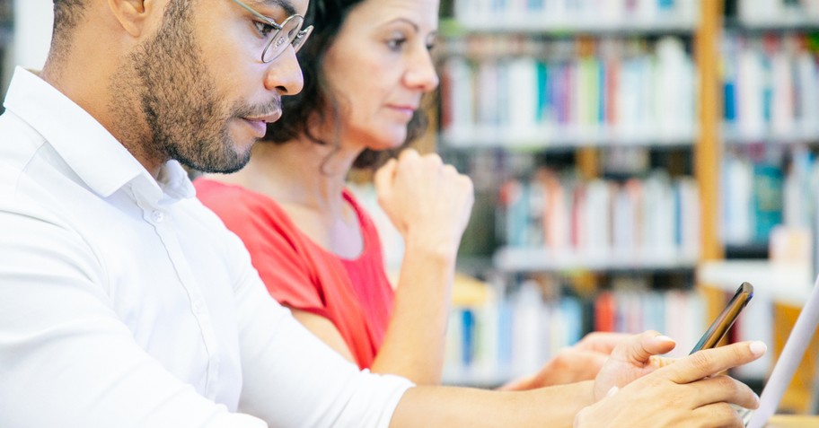 man and woman side by side on social media on laptop and smartphone