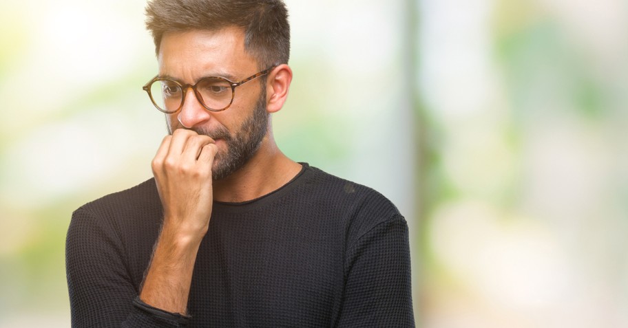 man biting nails scared worried