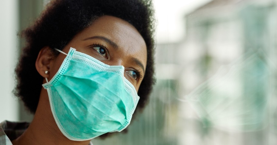 woman with mask leaning head on window looking tired and sad, what happened to 2020 vision hoped for