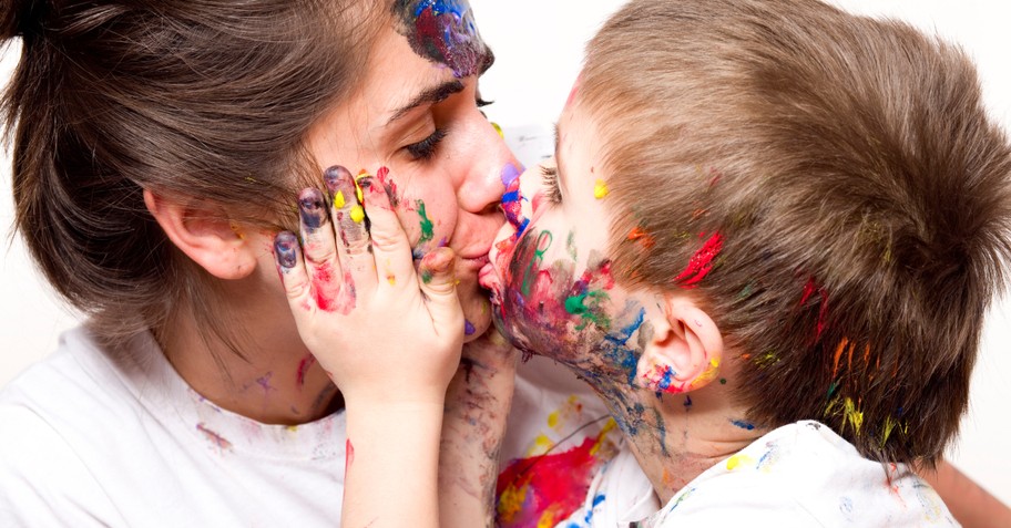 toddler kissing mom with messy paint hands and faces