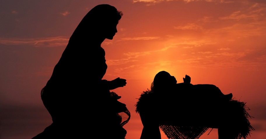 Mary and Baby Jesus silhouette against orange sky background