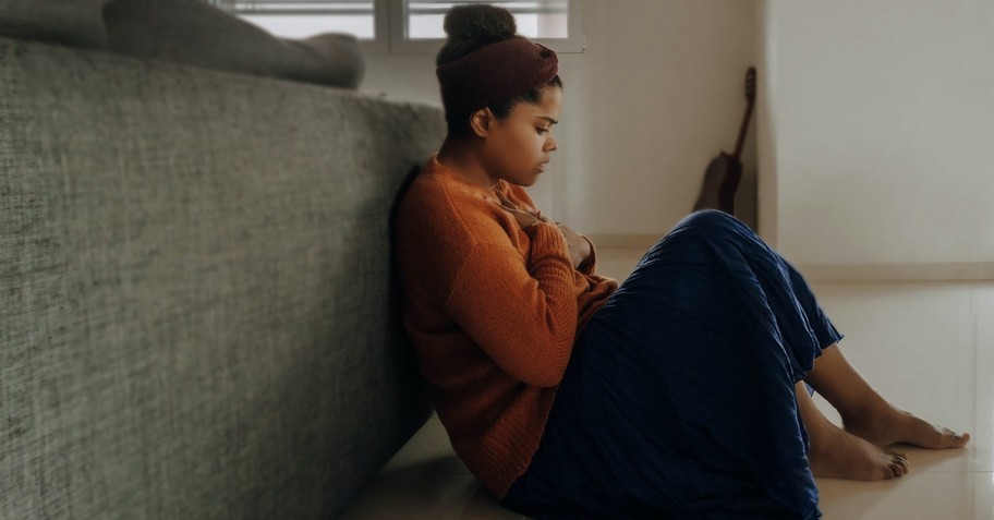 woman looking anxious and afraid sitting on the floor