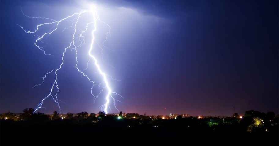 A large lightning bolt hitting above a city skyline
