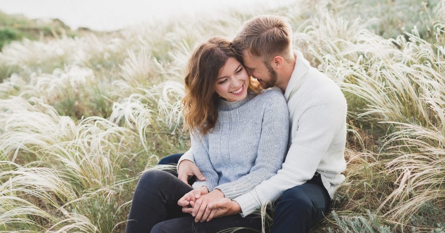 Engagement photos of a couple in a field