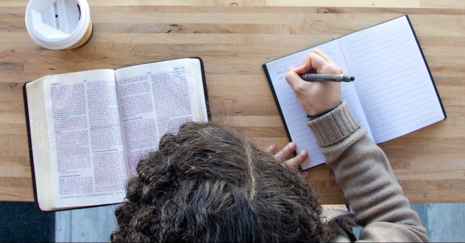 Woman at desk with Bible, notebook and pen