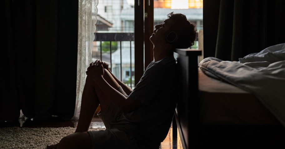 Anxious, stressed man sitting on the floor in the dark
