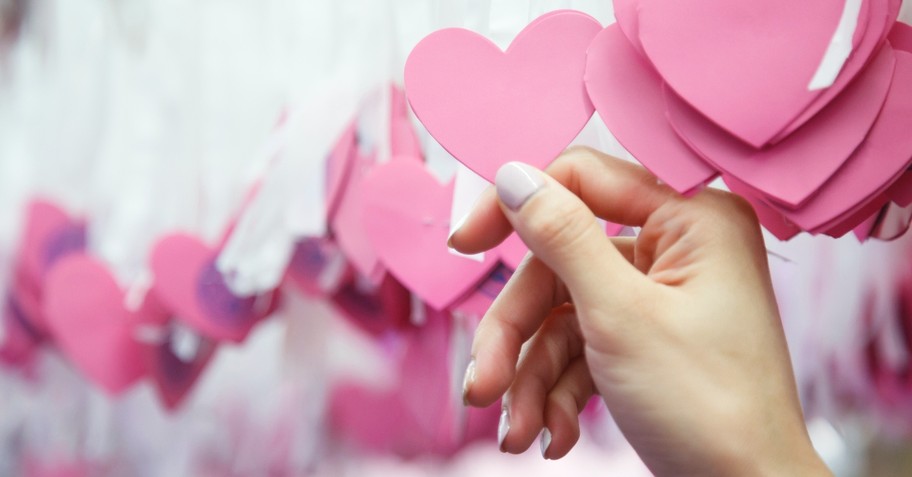 Woman reaching for one paper heart