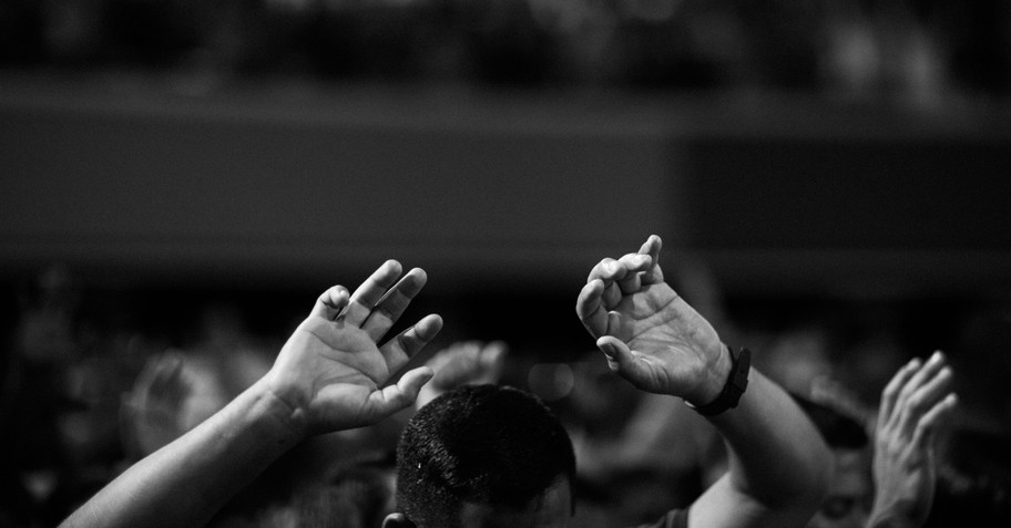 Man in church with hands raised