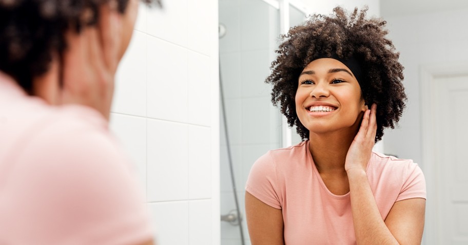 woman looking at herself in mirror and smiling