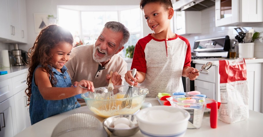 Granddad and grandkids baking cupcakes and laughing