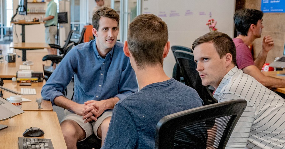 Three men chatting at work