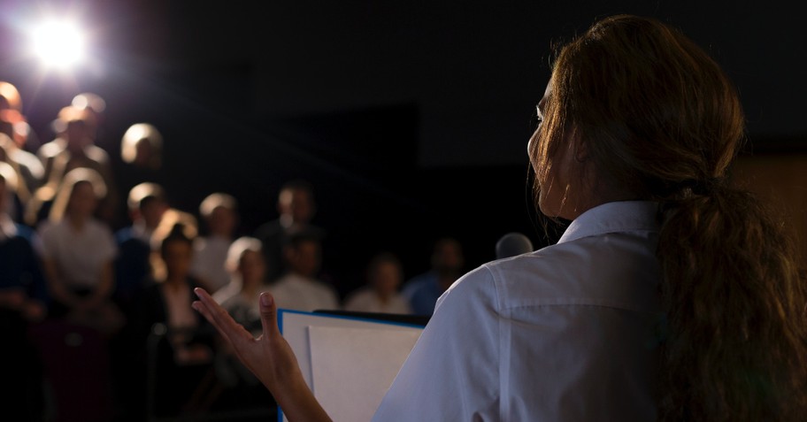 Woman speaking before a crowd, what is a false prophet