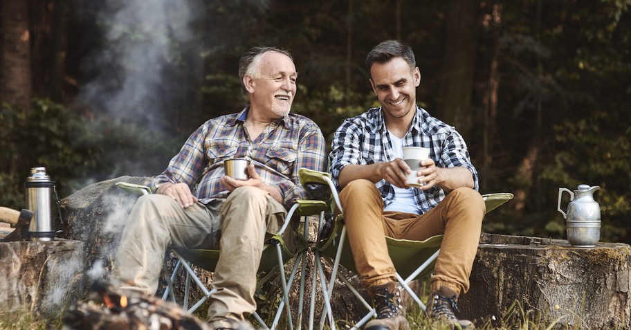 Senior dad with adult son campfire