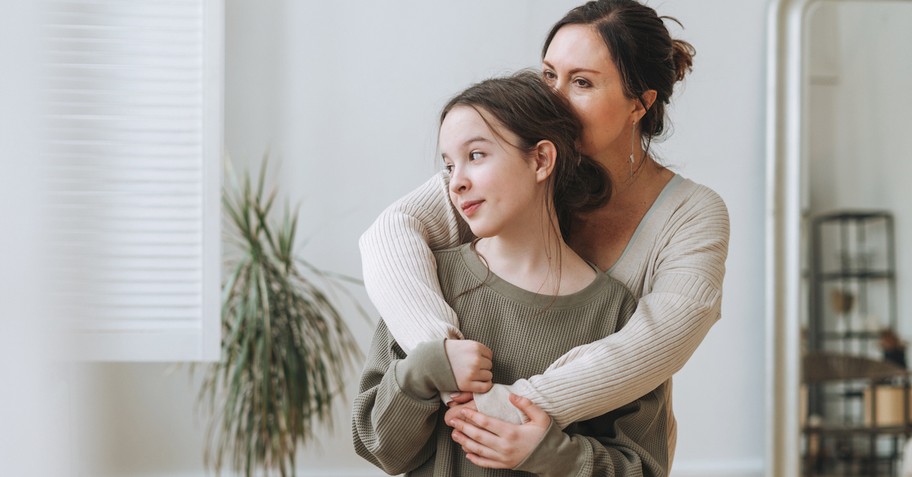 Mom and teen daughter hugging