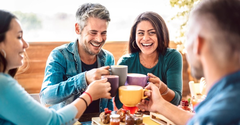 Friends clinking coffee mugs together, phileo love