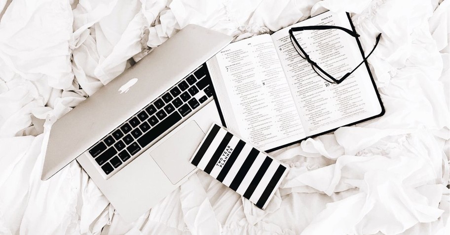 Bible, journal, laptop, and glasses