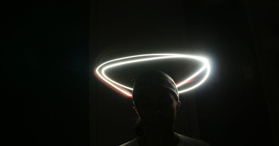 Teenager in the Dark with a Halo of Light over His Head