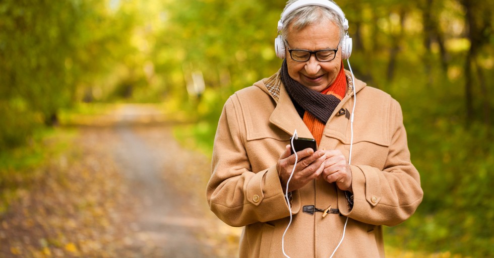 senior walking listening to bible on headphones