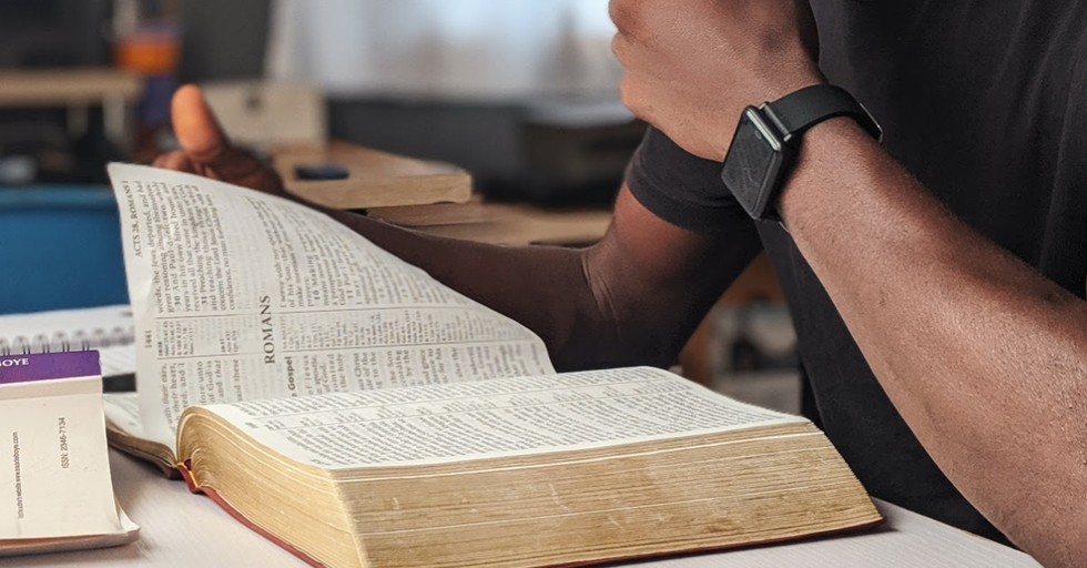 A man reading a Bible, man argues that protesting isn't going to change anything