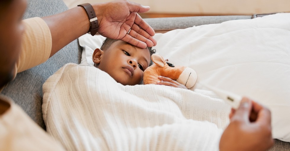 Sick kid in bed dad taking temperature