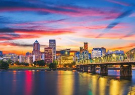 Downtown Portland skyline with Mount Tabor in the distance on a clear day, representing local business and community in the city.